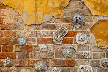 An old brick wall with peeling plaster.