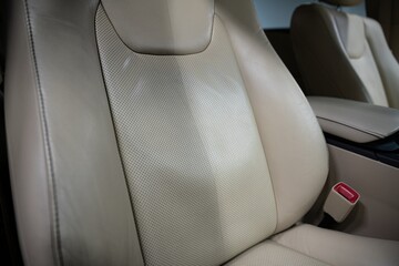 Before and after effect of cleaning leather upholstery in a car. Demonstrates professional auto...