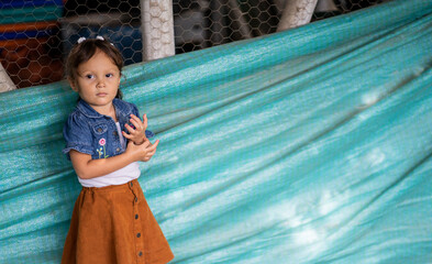 niña mirando la cámara en el pasillo de una granja 