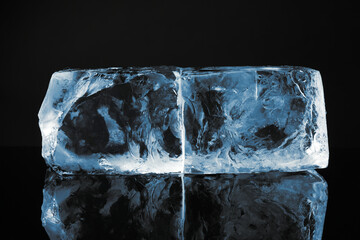 Blocks of clear ice on black mirror surface