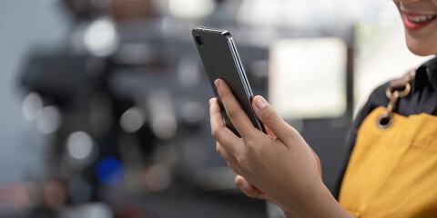 Young Barista Using Smartphone in Modern Cafe, Close up of Hands Holding Mobile Device, Technology and Communication Concept