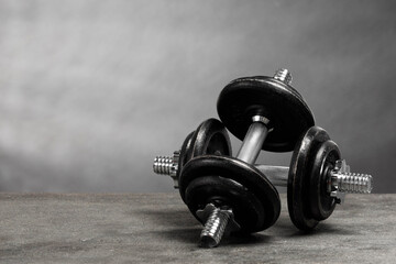 Obraz premium Two barbells on grey textured table. Space for text