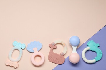 Bright rattles on color background, flat lay with space for text. Baby accessories