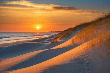Picturesque sunset casts warm glow over rolling sand dunes on beach