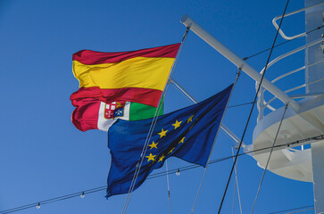 Italian, European Union and Spanish flag on mast of modern cruiseship cruise ship liner against...
