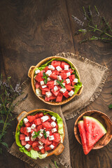 Fresh watermelon salad with feta cheese and mint on rustic wooden background