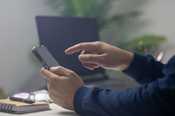 Men's hands on the table use mobile phones, technology, communications, the Internet.