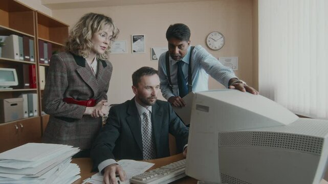 Arc medium long shot of team of diverse male and female office workers developing business project on old vintage computer, clerk typing and colleagues giving ideas gathered by him, nostalgic 90s - Powered by Adobe