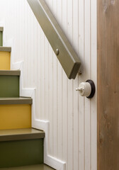 A colorful and stylish staircase with unique design and white wall paneling for modern look