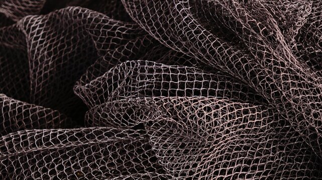 waving fabric of dark fishing net as a background