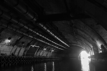 Industrial concrete tunnel perspective with glowing exit gateway