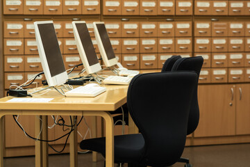 computer terminals in a modern library with blurred catalog cabinets in the background