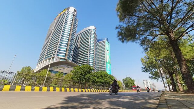 Islamabad, Pakistan - 12th october, 2023: static timelapse vehicles drive in traffic in Pakistans capital city by famous The Centaurus Mall, Islamabads premier shopping and entertainment destination