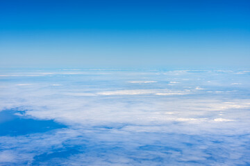 Aerial view of a sea of white clouds above the ocean.