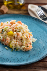 Risotto de camarão na mesa de madeira e prato azul (arroz de camarão)