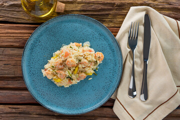 Risotto de camarão na mesa de madeira e prato azul (arroz de camarão)