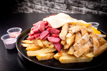 Peruvian culinary: Salchipapas, a fast food made with fried potatos, sausage, egg, bacon and many sauces like ketchup, mayonaise, mustard and hot pepper and chicken