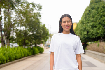 Young Thai Woman Smiling Outdoors in Casual Clothing