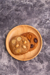 chocolate macadamia soft cookies on a table and plate
