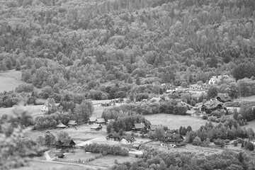 black and white photo of a village among forests and mountains in the Bieszczady Mountains in Poland