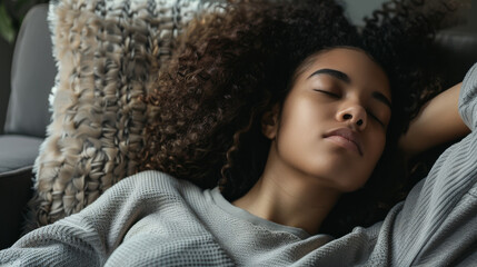 A woman peacefully asleep on the sofa, embraced by warm, soft pillows, and the serenity of a cozy afternoon.