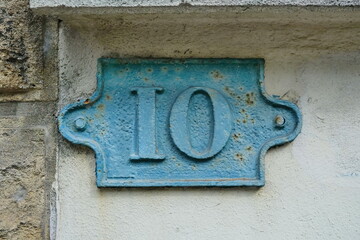 Old iron sign with number 10. Iron old sign or plate, blue color. Street house number. Traces of rust.