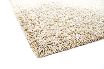 Close up of a beige carpet with fringe