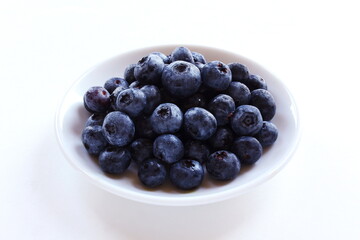 fresh blueberries or bilberry fruit in bowl isolated on white background,top view