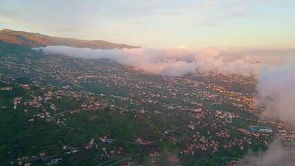 Aerial view village mist on sunset. Beautiful fog rolling green island hillside