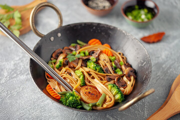 Wok noodles with mushrooms, broccoli, carrots and green onions.