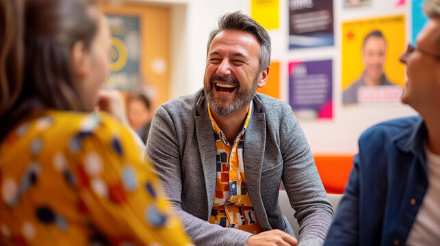Cheerful Middle-Aged Man Laughing in a Casual Business Meeting with Colleagues - Powered by Adobe
