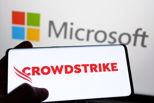 CrowdStrike and Microsoft logo seen on screen of smartphone and laptop. Cybersecurity company behind the global IT outage. Stafford, United Kingdom, July 19, 2024