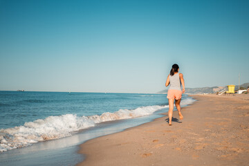Woman embracing a healthy lifestyle with a beach run.