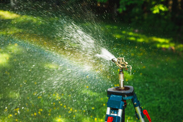 garden sprinkler on a tripod watering new lawn