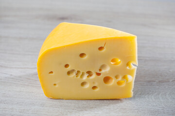 maasdam cheese on wooden background, close-up view