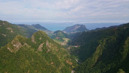 Obraz premium Green hillsides dense forests covering steep cliffs drone view. Scenic mountains