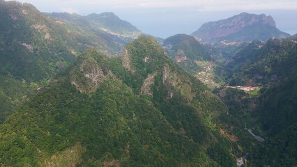 Scenic green mountains rising over lush valleys in remote landscape drone view. 