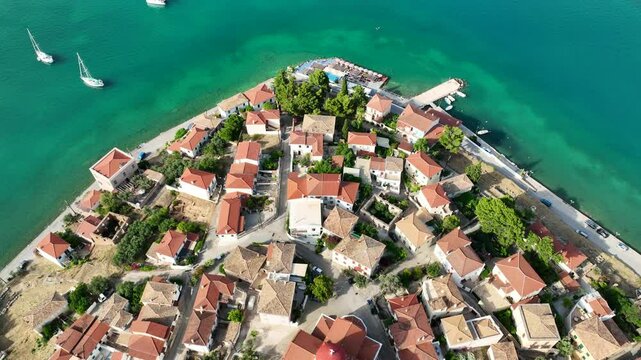 Aerial drone video from picturesque and traditional historic seaside village of Galaxidi featuring landmark church of Agios Nikolaos, Fokida, Greece