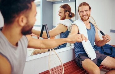Fototapeta premium Men, team and fist bump for sports, fitness and game in competition as collaboration and motivation. Athlete, cooperation and hand touch for squash, exercise and thank you together in locker room