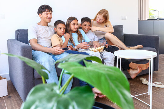Triplets and siblings enjoying a movie at home