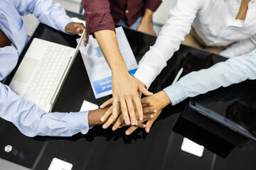 Group of educators joining hands in a teamwork gesture