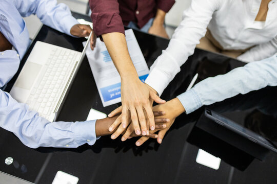 Group of educators joining hands in a teamwork gesture