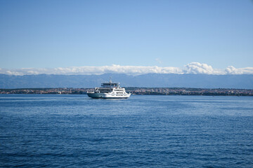 A ferry sailing across the Adriatic Sea to a Croatian island with mountains in the background on a...