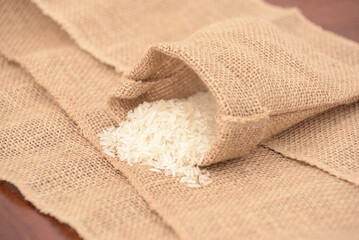 A bag of rice is sitting on a table with a piece of burlap cloth