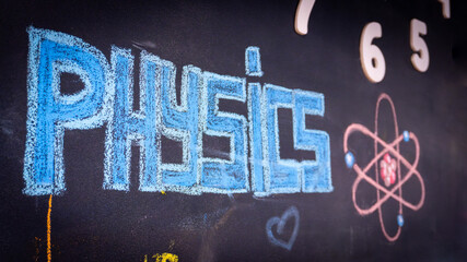 Physics inscription on the black wall with the atom icon