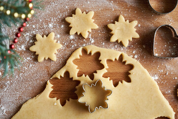 Cutting out star shapes from raw pastry dough to prepare traditional Linzer Christmas cookies