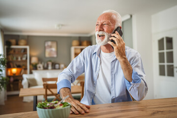 Senior man have a phone call while eat salad at home