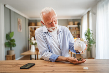 Senior man count money from the piggy bank and save money at home