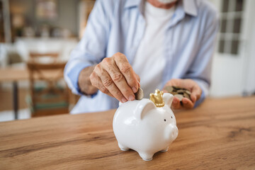 Senior man count money from the piggy bank and save money at home