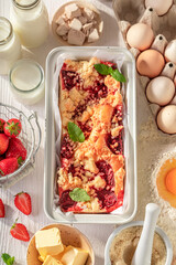 Fresh and hot strawberry yeast cake with crumble and fruits.